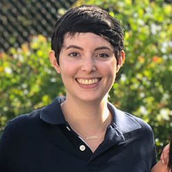 A diverse crowd of people celebrating at a concert, raising their hands and cheering.