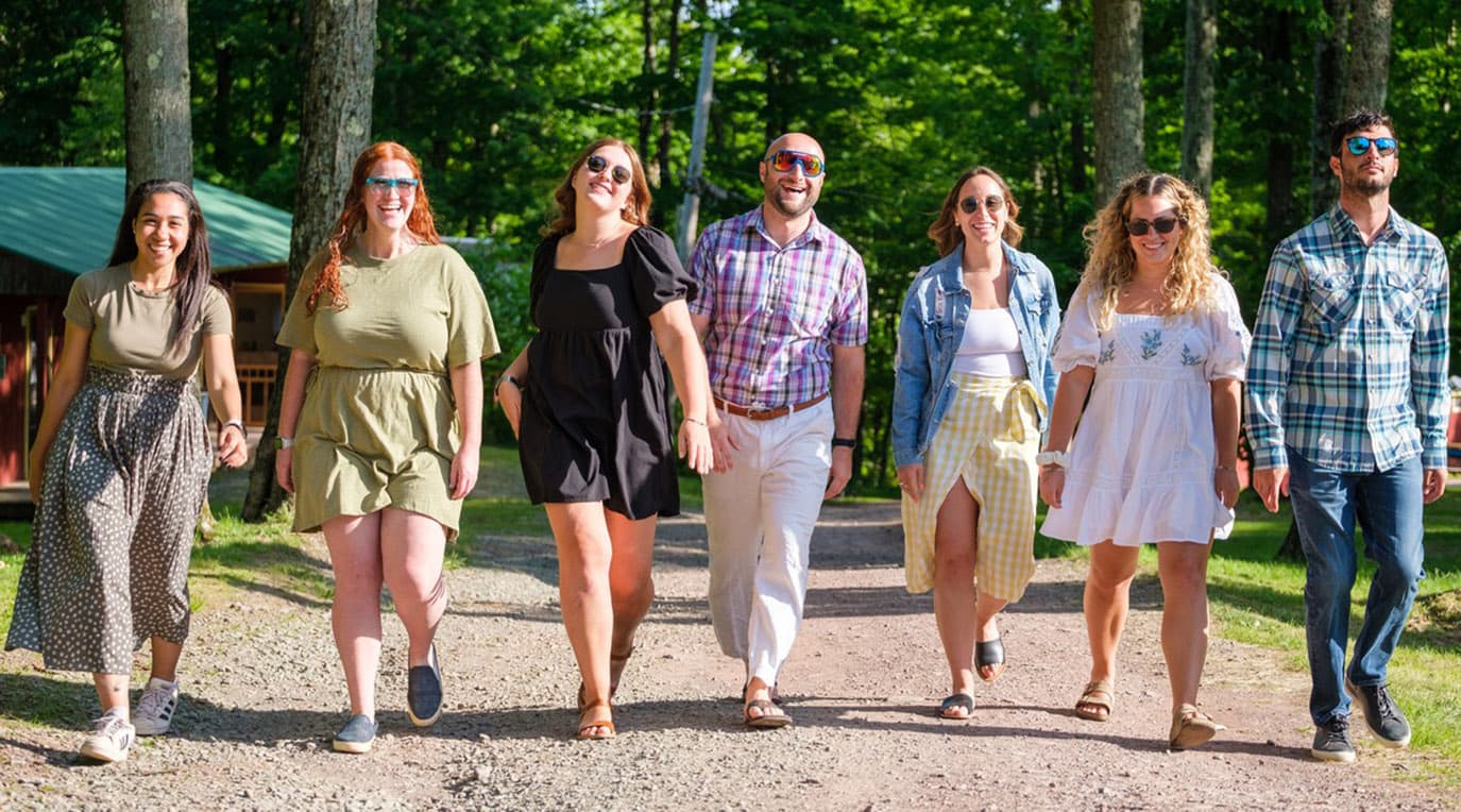 A diverse crowd of people celebrating at a concert, raising their hands and cheering.